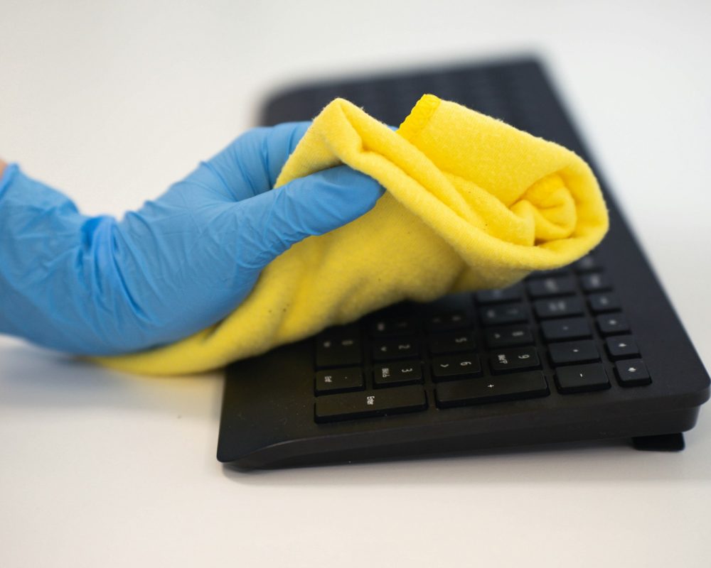 Cleaning the office with a microfiber cloth and gloves